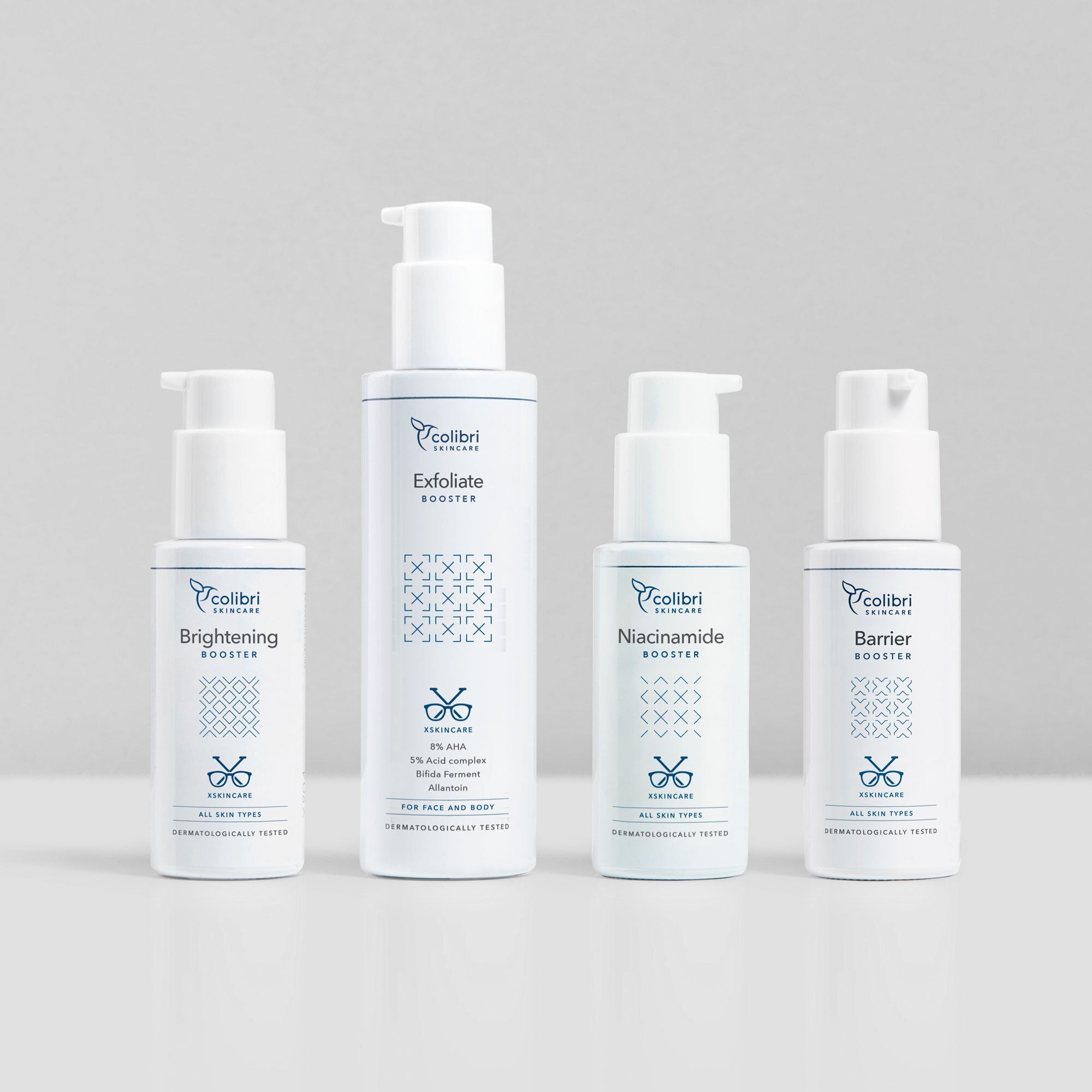 Vier weiße Hautpflegeflaschen mit verschiedenen Boostern auf einem hellen Hintergrund.