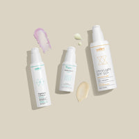 Drei Flaschen Hautpflegeprodukte auf beigem Hintergrund mit Farbflecken, darunter Pigment Control, Antioxidant Serum, SPF 50+.